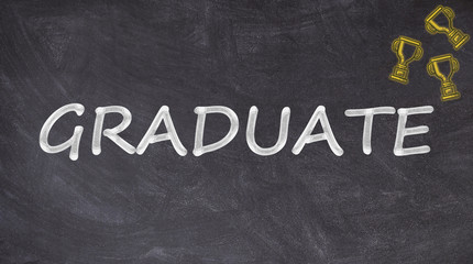Obraz premium Graduate written on blackboard with trophies
