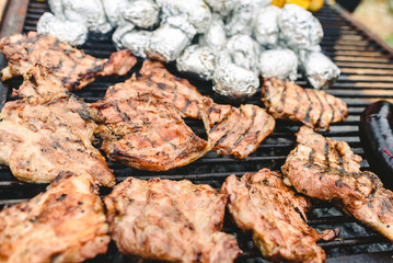 Sausage, pork and chicken roasted on a barbecue, seen from above.