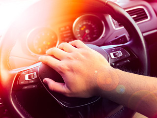 Driver's hands on the steering wheel inside of a car, Driving in the sun on a car