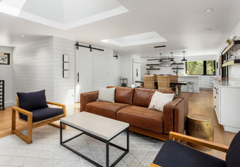 Beautiful white living room, dining room, and kitchen in new home interior with open concept floor plan. 