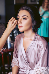 Young make-up artist makeup. Wedding morning of the bride.