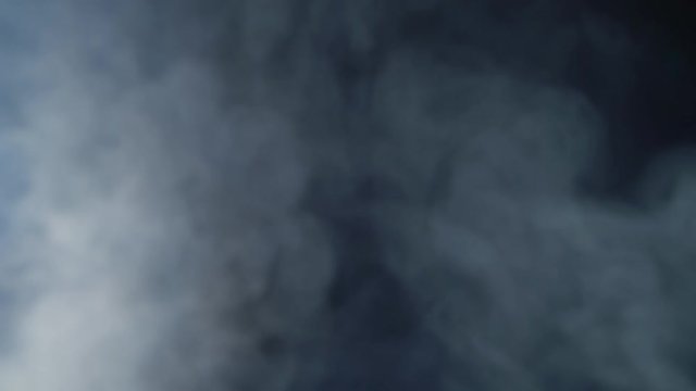 Smoke cloud on black background in blue light