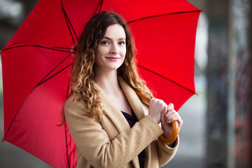 Young beautiful woman with red umbrella outdoors