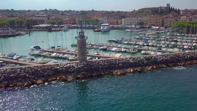 Aerial view of boats and lighthouse in Lake Garda, Italy.