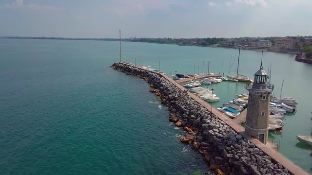 Aerial view of boats and lighthouse in Lake Garda, Italy.