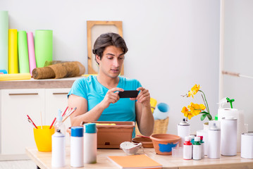 Young man decorating pottery in class