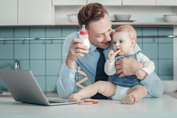Do you want. Pleasant caring handsome father spending time in the kitchen with his children smiling...