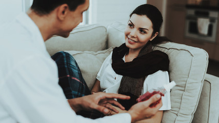 Doctor Visiting Sick Young Woman in Scarf at Home.