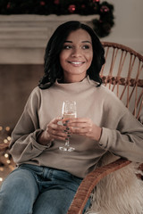 Time to dream. Pretty brunette expressing positivity while celebrating New Year, holding bocal in both hands