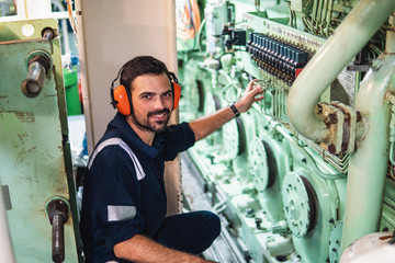 Marine engineer officer in engine control room ECR. Seamen's work. He starts or stops main engine of ship