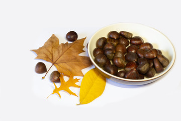chestnuts dish and leaves on white background
