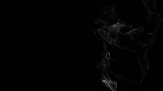 Smoke floating through space against black background. Slow motion