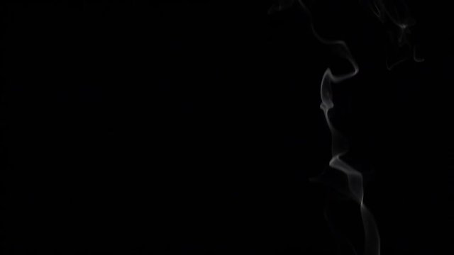 Smoke billowing over a black background. Slow motion