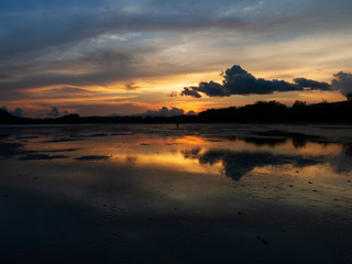 silhouette sunset on a beautiful Krabi Thailand beach. gold color sky sunset soft smooth sand beach.