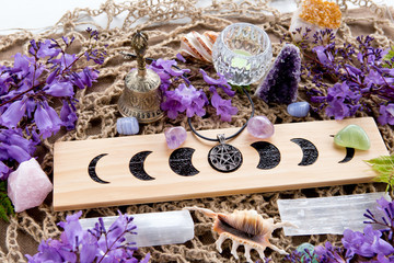 Full Moon Witch Pagan Altar decorations with Moon Phases, crystals, purple flowers and pentacle pendant