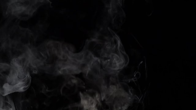 Smoky clouds over a black background. Slow motion