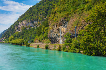 Fototapeta na wymiar The Aare river flowing along the slope of Mt. Harder in the city of Interlaken, Switzerland