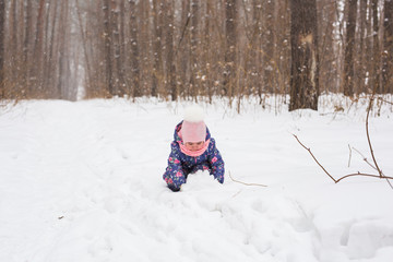Fototapeta na wymiar Childhood and nature concept - Adorable child playing in winter park