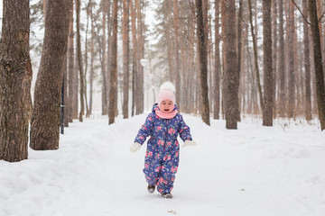Childhood and nature concept - Adorable child playing in winter park