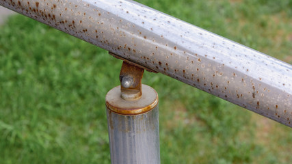 chrome rusty steel railing fixed on post on the nut