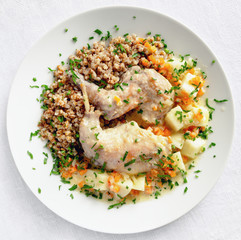 braised with carrot, onion, celery, sour cream, and apples rabbit legs garnished with buckwheat and decorated with parsley 