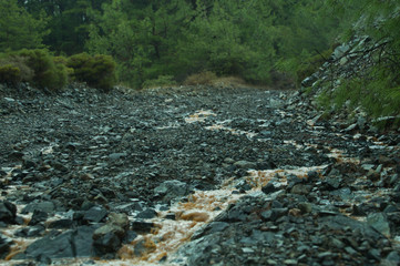 Mountain uneven dirt road with puddles. gray relief