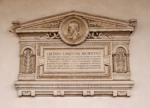 Milan, Lombardy, Italy. Memorial plaque on the wall of the Basilica of Sant'Ambrogio. In the church of Sant Ambrogio there are relics of St. Ambrose of Milan and the martyrs Gervasius and Protasius