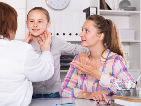 Little girl talking with doctor about sick of throat