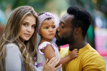Fototapeta premium African American father and a white mother with a daughter in her arms.