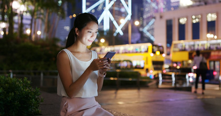 Woman look at the cellphone in city