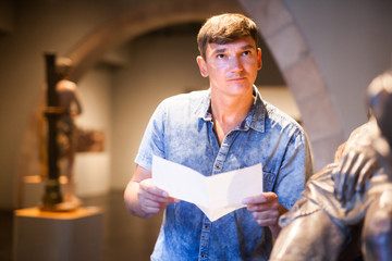 Man with brochure looking at exposition