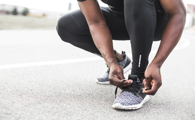 Young sportsman tying shoelaces on sport shoes. Fit, fitness, exercise, workout and healthy lifestyle concept. free space for text