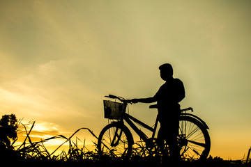 Fototapeta premium A boy fitness silhouette sunrise cycling workout wellness concept