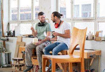 two worker in a carpenter's workshop taking a break