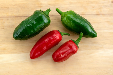 Pepper capsicum annuum Jalapeno chilli hot peppers, group of green and red fruits on wooden table