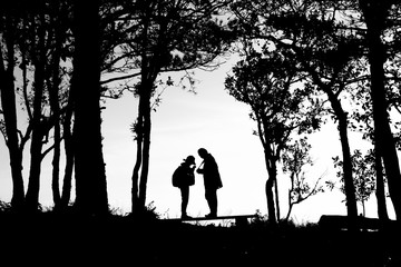 silhouette of love couple in trees border, back and white tone