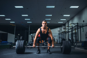 Fototapeta na wymiar Male powerlifter starting deadlift barbell in gym
