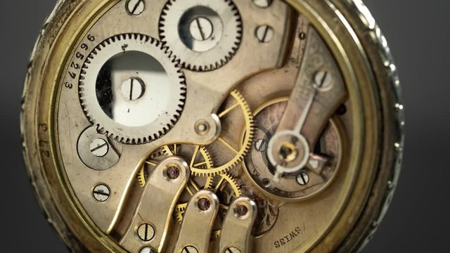 Mechanism vintique pocket watch against rotate the black background. Time lapse