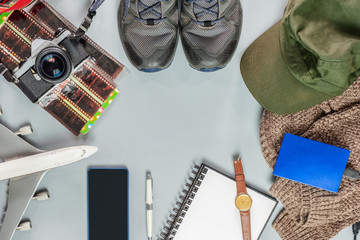 Travel accessories on vacation with vintage camera, airplane, shoes, notebook, coat, hat, hard disk on gray background
