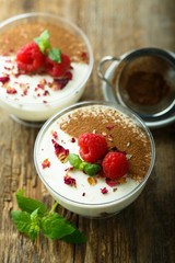 Homemade tiramisu dessert decorated with fresh raspberry and rose petals