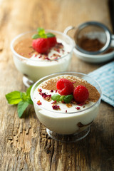 Homemade tiramisu dessert decorated with fresh raspberry and rose petals