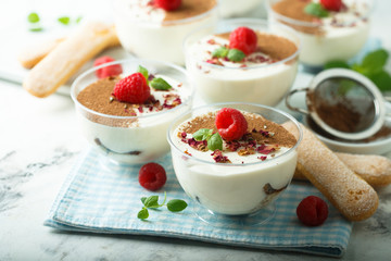 Homemade tiramisu dessert decorated with fresh raspberry and rose petals