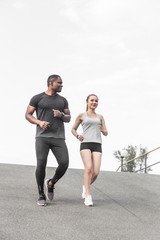 happy young couple afro-american man and european woman running together. A loving couple is run, engaged in sports, family values
