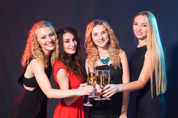 Party, holidays, celebration and nightlife concept - smiling female friends with glasses of champagne in club