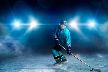 One hockey player on ice, spotlights on background