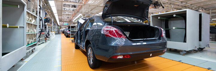 Car without doors on production line. Long format. Wide angle view of plant of the automotive...
