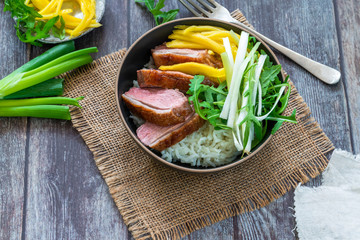 Hoisin duck with mango, spring onion, rocket lettuce salad and rice - top view
