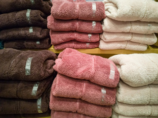 Sweater, many colors folded stacked on the floor. In the mall,soft focus.