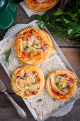 Mini pizza with sausage, top view, selective focus