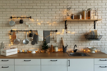 New Year and Christmas 2018. Festive kitchen in Christmas decorations. Candles, spruce branches, wooden stands, table laying. - 232759194